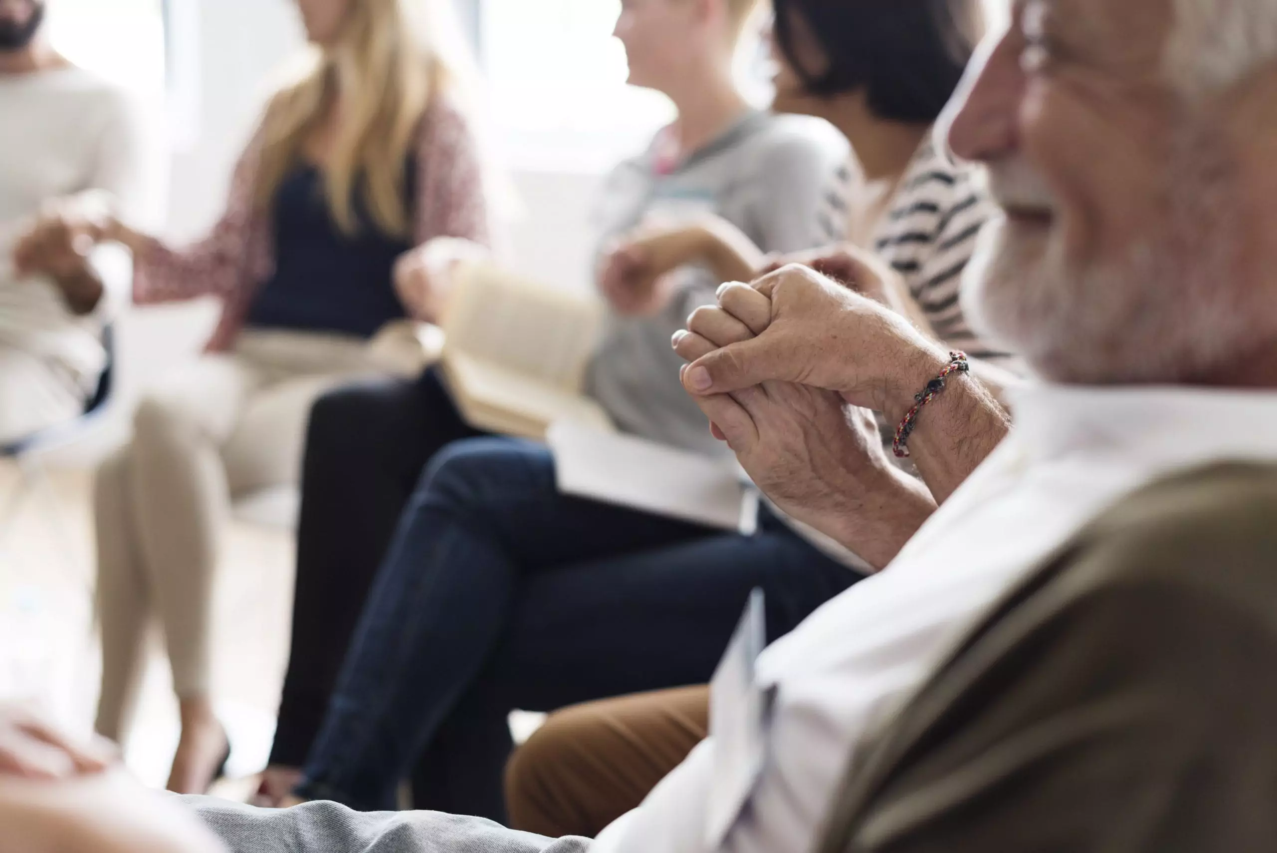 Support group members holding hands and smiling