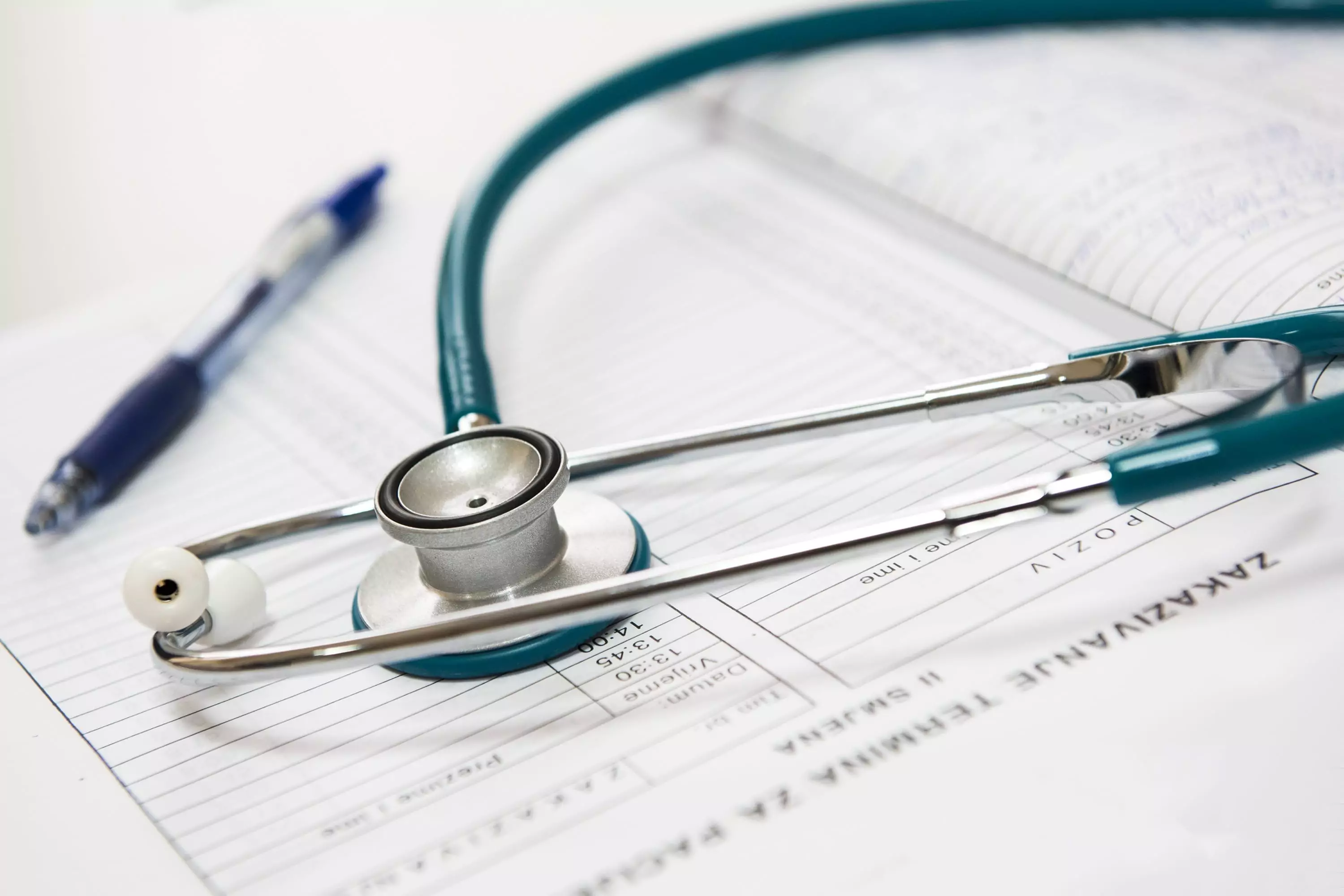 Pen and stethoscope on notebook with notes from a doctor