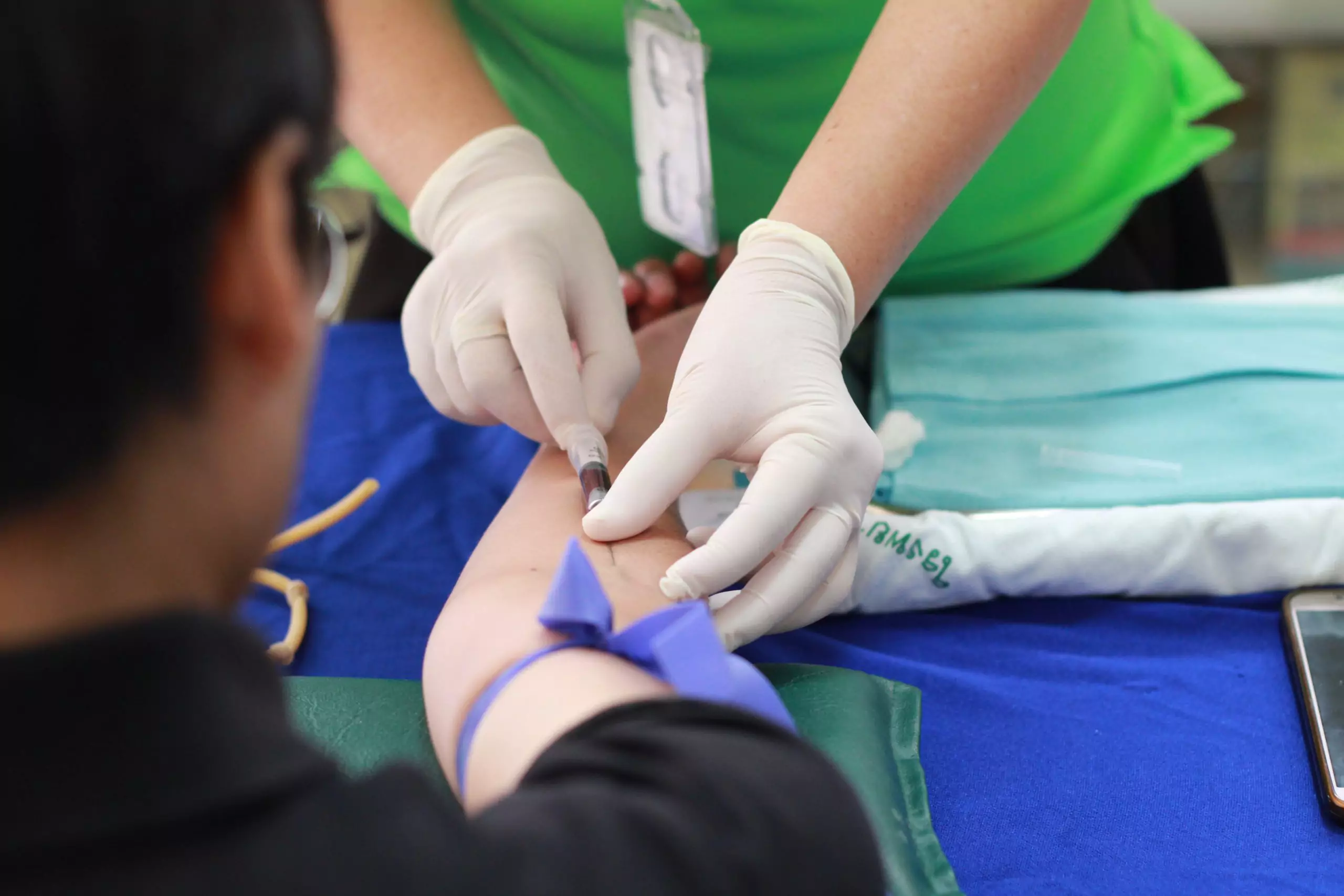 A person getting blood drawn by a nurse