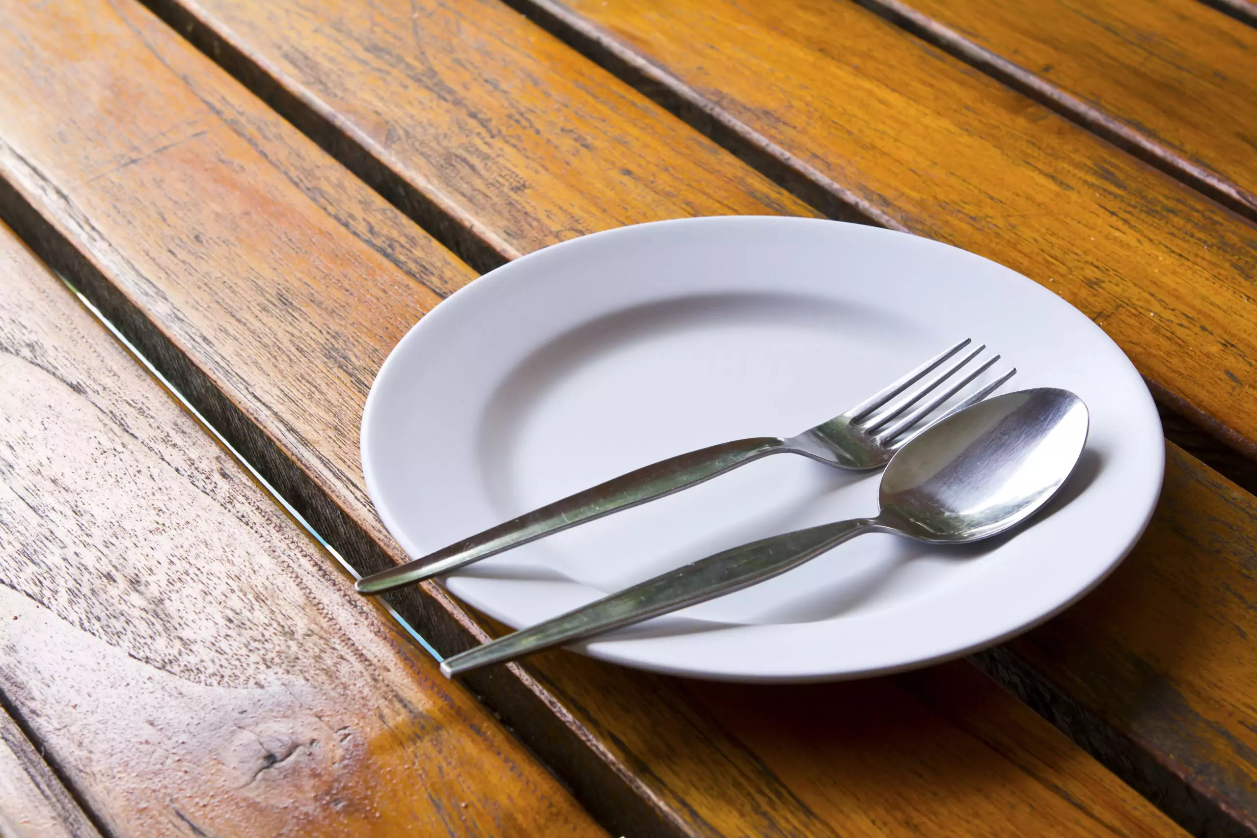 Empty plate with fork and spoon due to loss of appetite from kidney disease