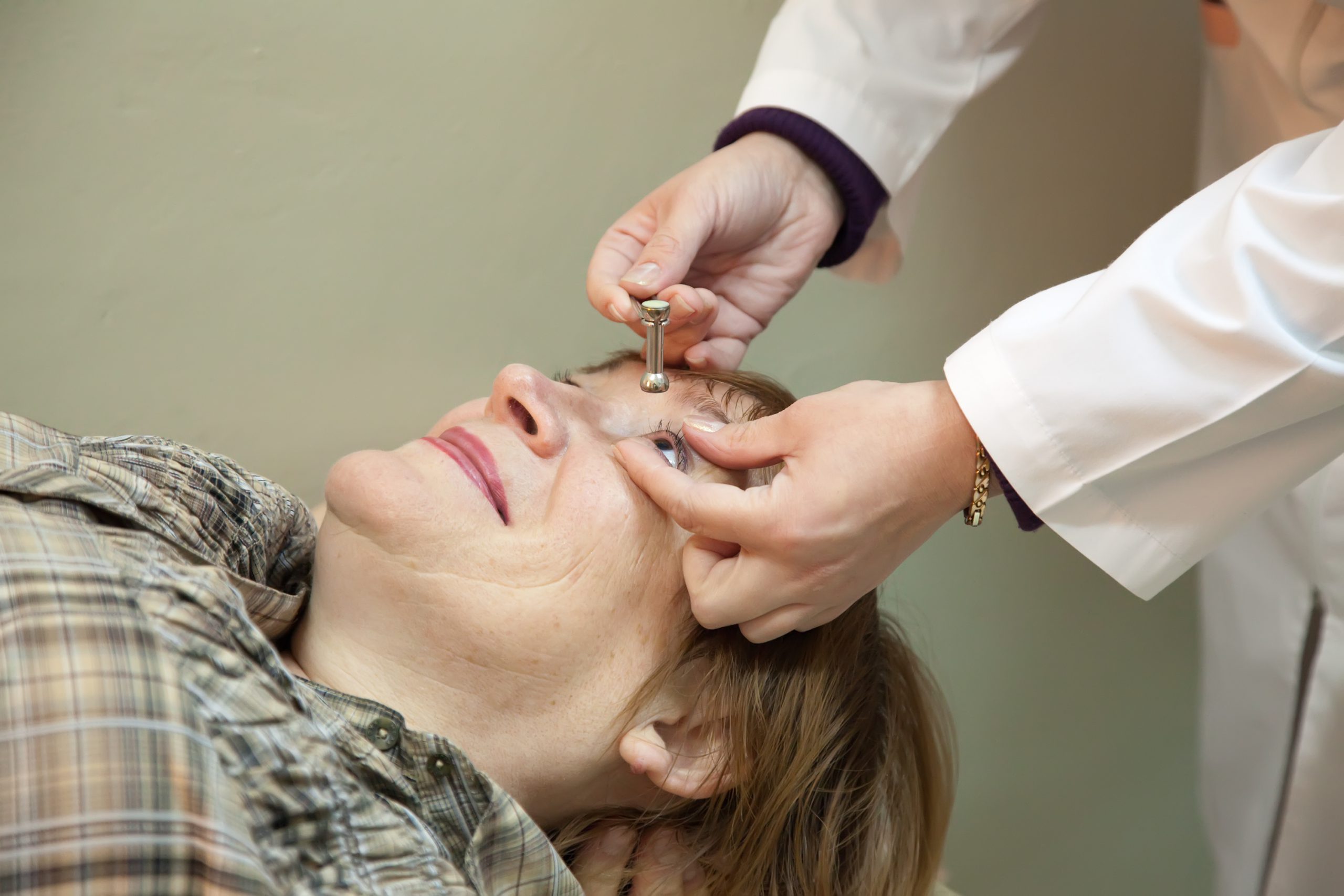 Ophthalmologist measures a patient's intraocular pressure (IOP) for glaucoma