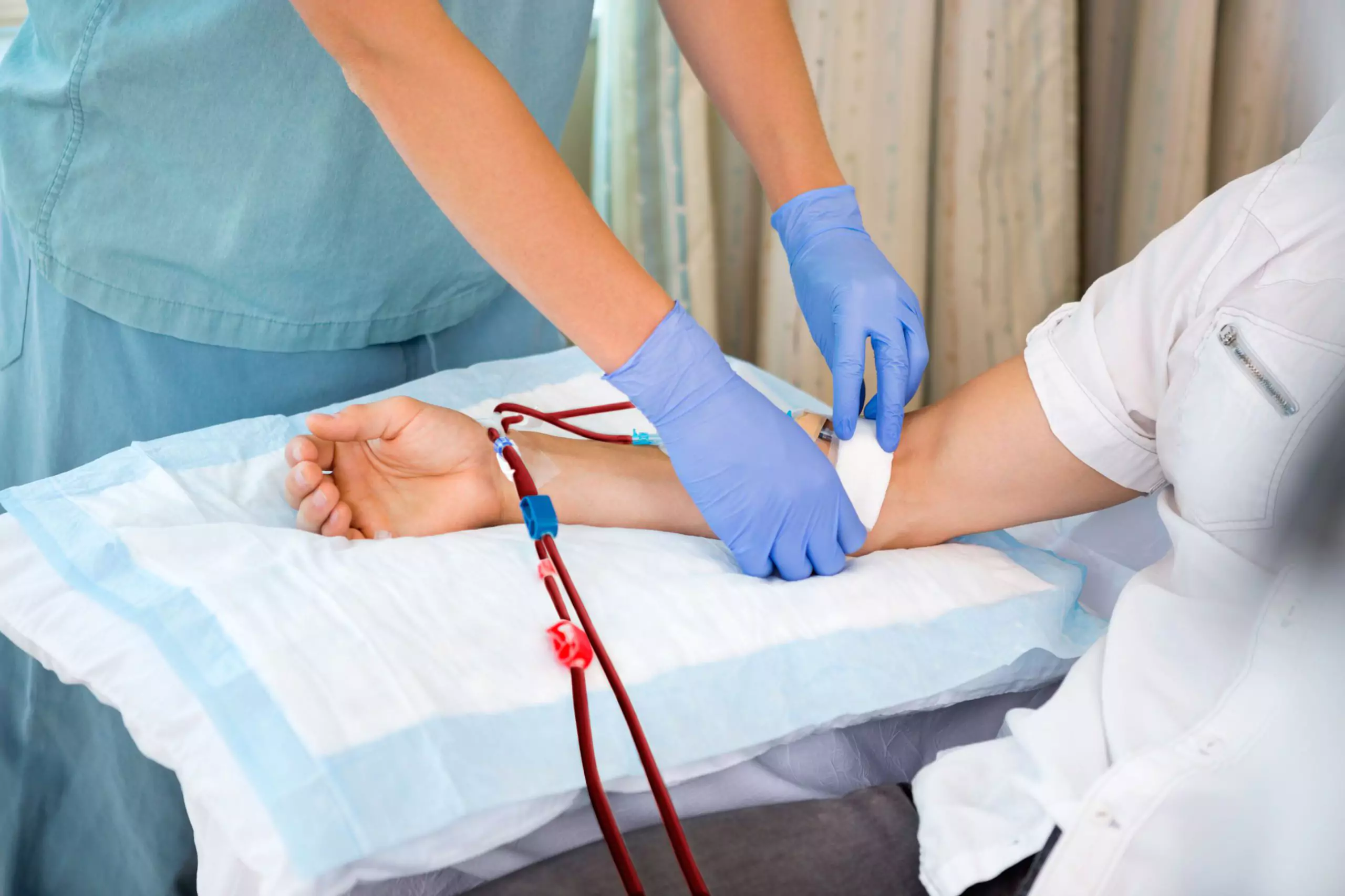 Nurse in renal unit at hospital starting dialysis on patient