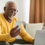 Senior Black Man Using Mobile Phone Smiling